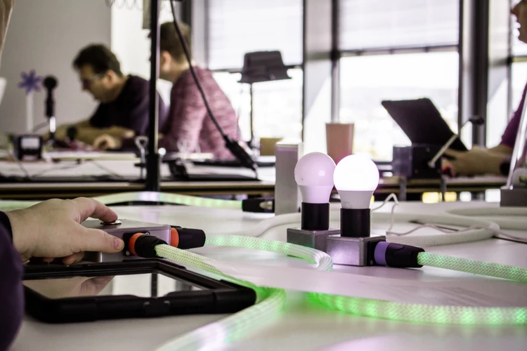 Personen bedienen ein interaktives Energietisch-Modell mit leuchtenden Markierungen.