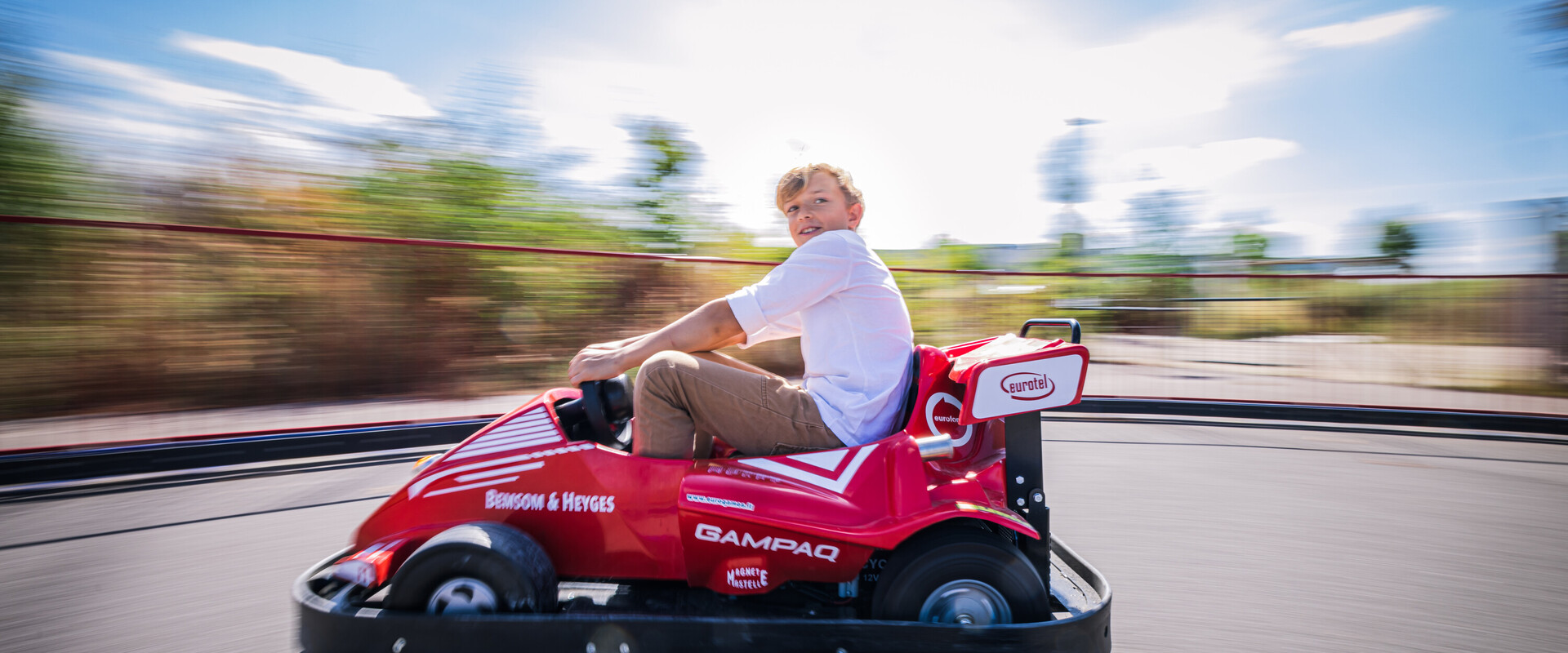 Ein Junge auf der E-Kartbahn im Themenpark der KLIMA ARENA.