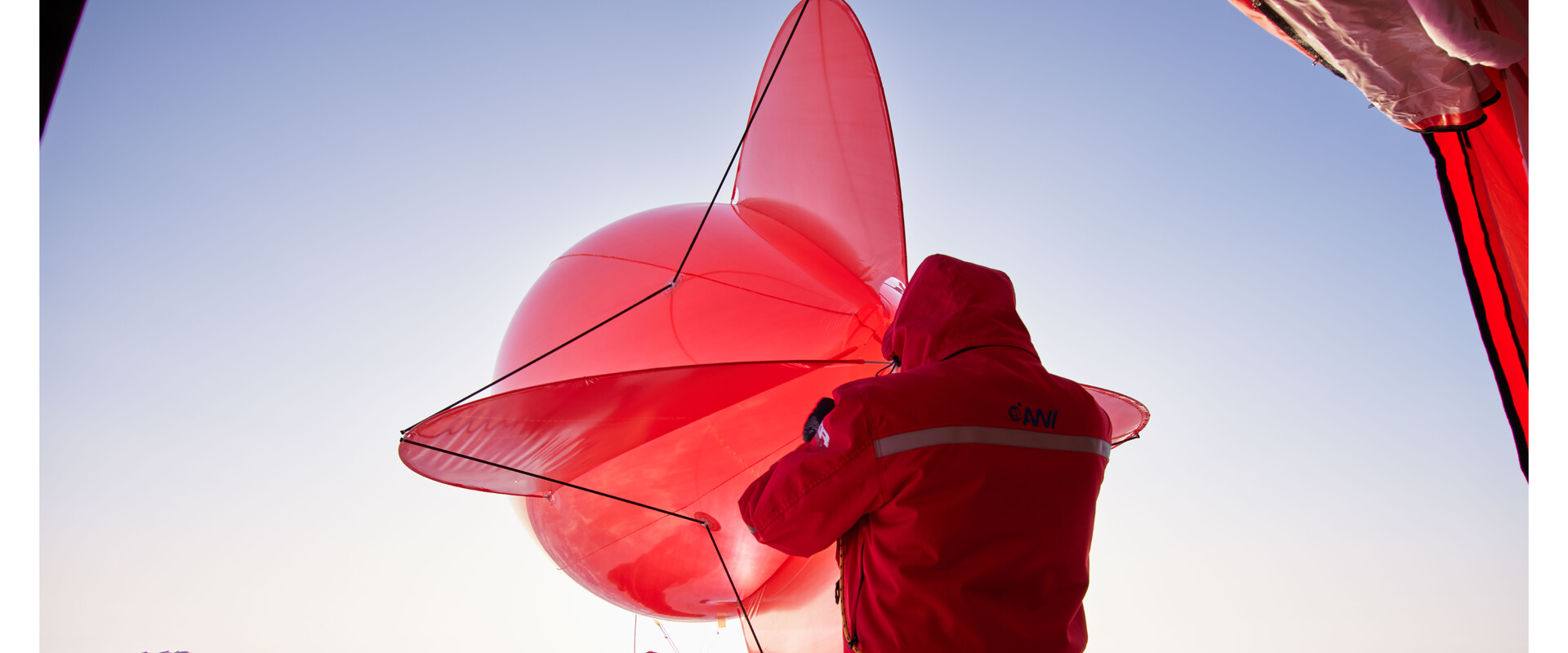 Wissenschaftler in Schutzanz&uuml;gen lassen einen Wetterballon steigen.